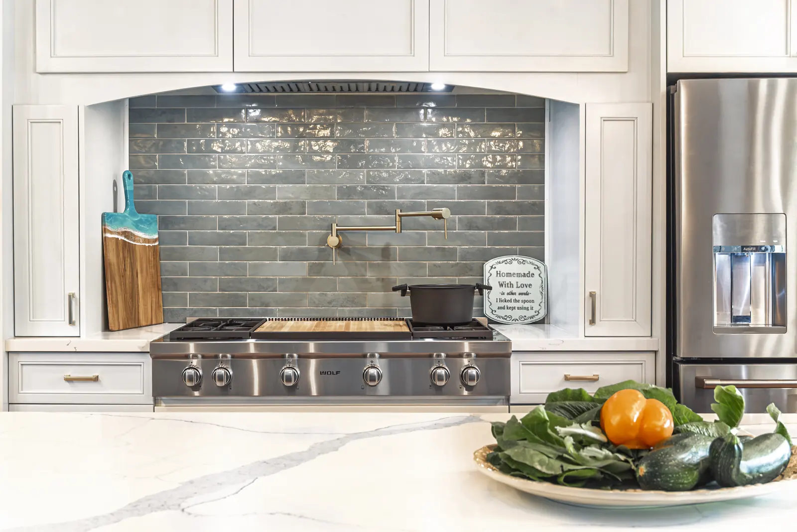 Cooktop with soft green tile and brass hardware selections, Refined Designs by Natalie