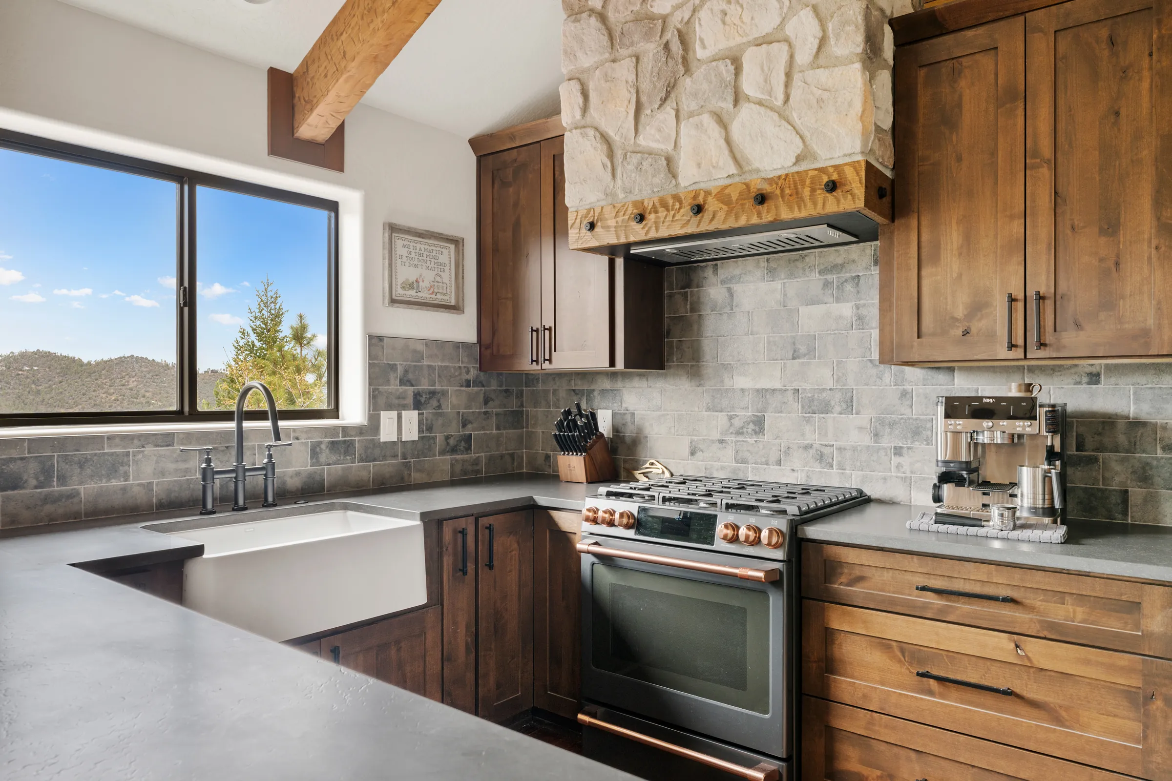 Remodeled cabin kitchen with stone range wall and timber beams, Daybreak at Ponderosa, Refined Designs by Natalie
