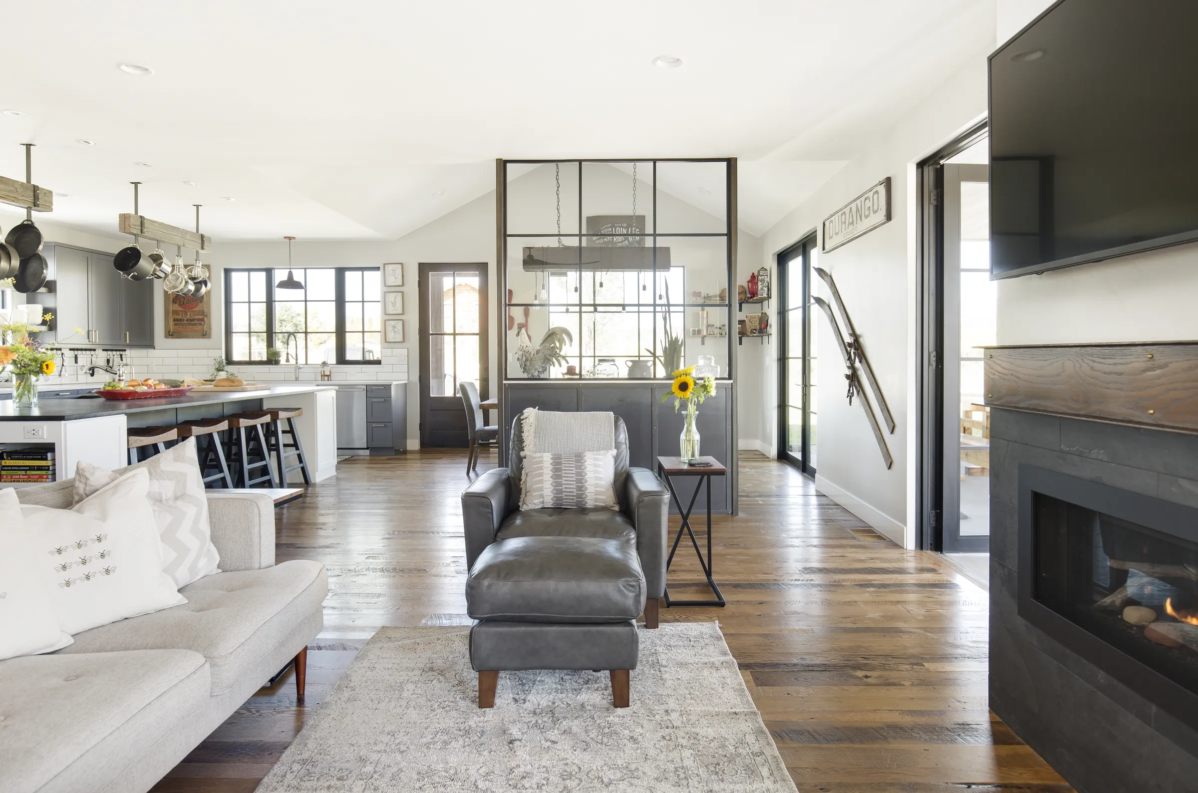 Open great room with fireplace and steel and glass partition, Bright and Airy Farmhouse, Refined Designs by Natalie