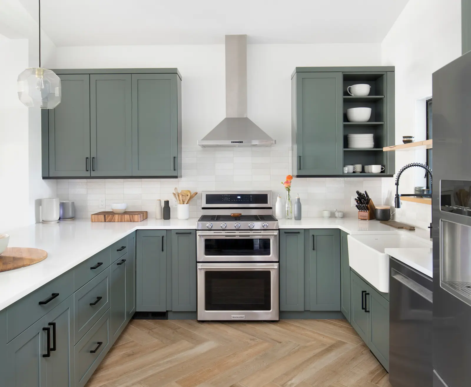 Green kitchen cabinetry and herringbone flooring in an early-1900s home, Historic Charm in a Small Town, Refined Designs by Natalie