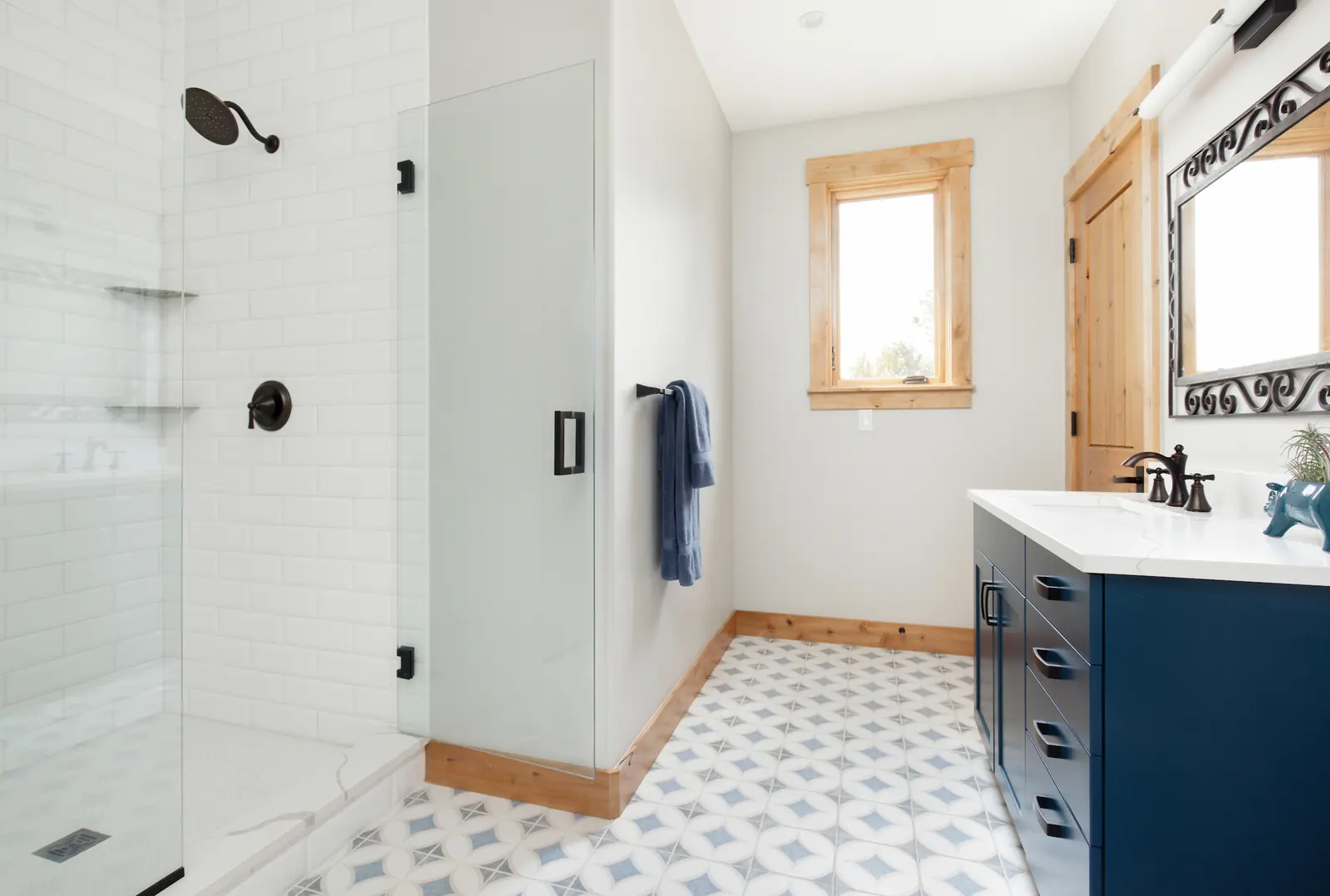 Guest bath with blue vanity and patterned floor tile, Glorified Garage, Refined Designs by Natalie