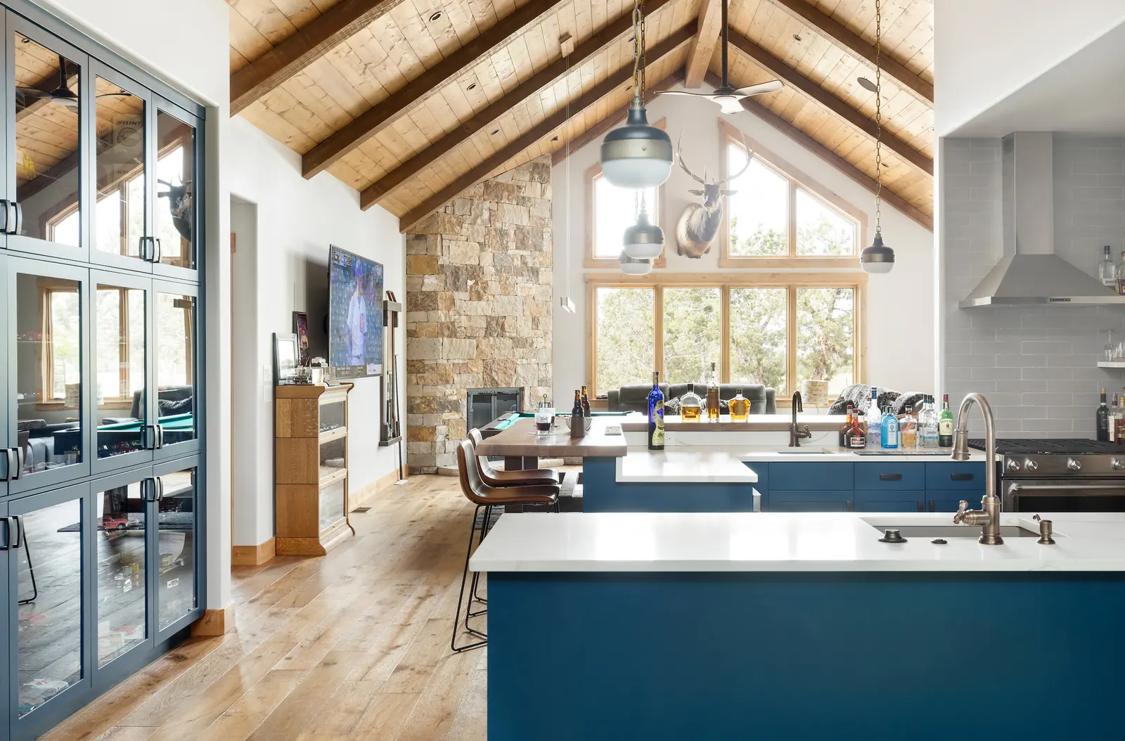 Kitchen with blue island under exposed trusses, Glorified Garage, Refined Designs by Natalie