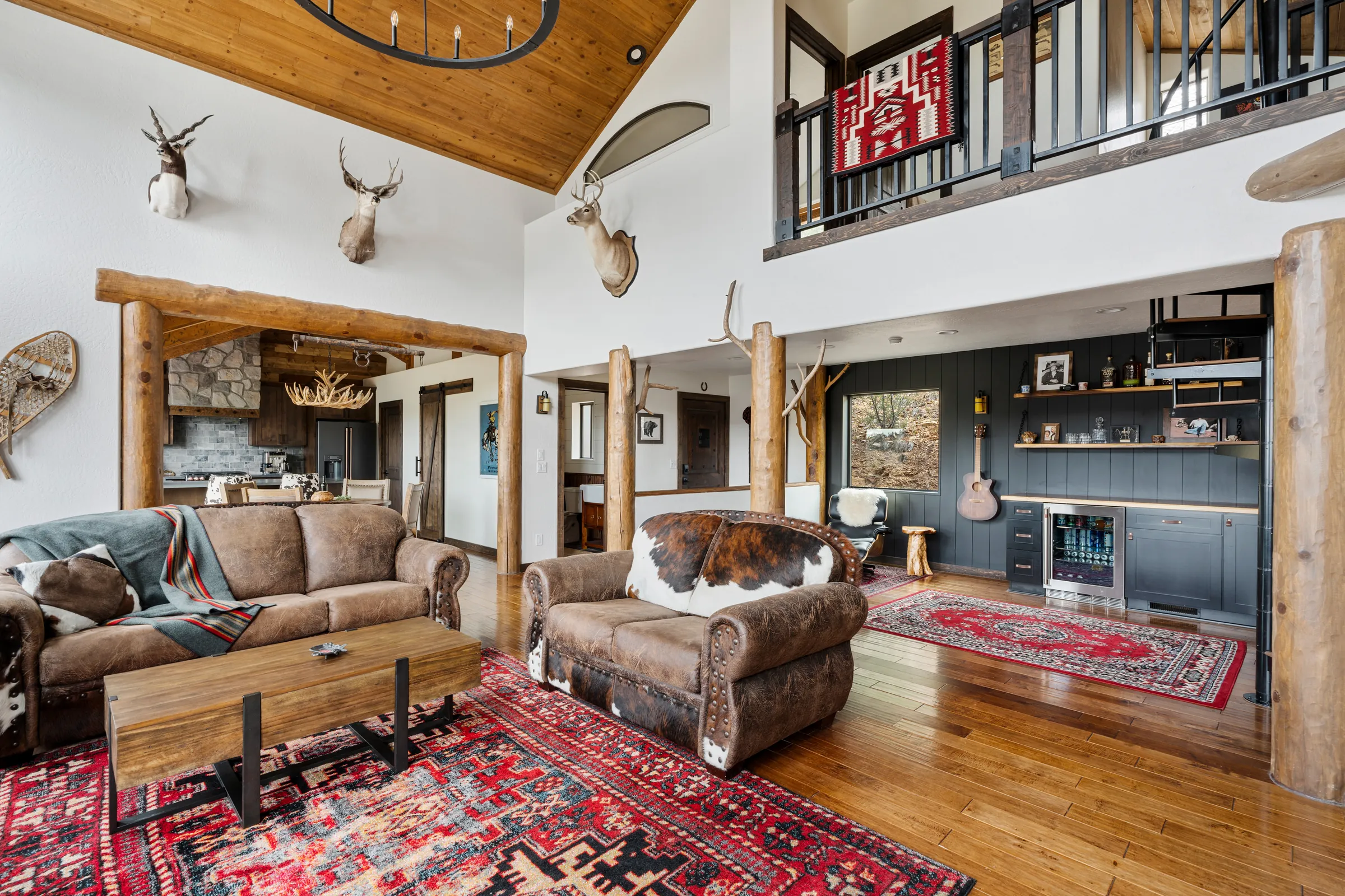 Remodeled great room with stone fireplace, timber posts and loft, Daybreak at Ponderosa, Refined Designs by Natalie