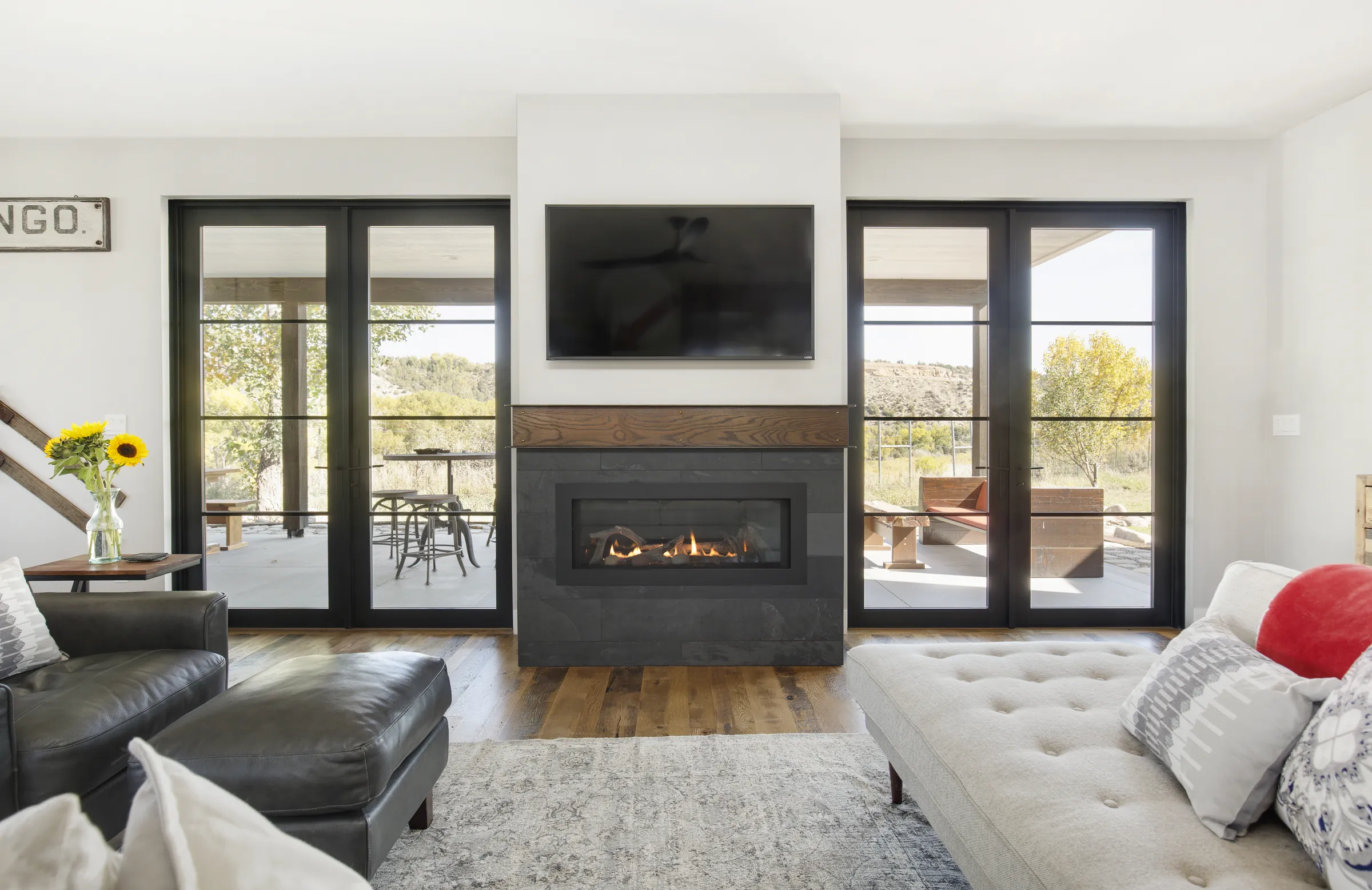 Finished living room with linear fireplace and black framed doors, Bright and Airy Farmhouse, Refined Designs by Natalie
