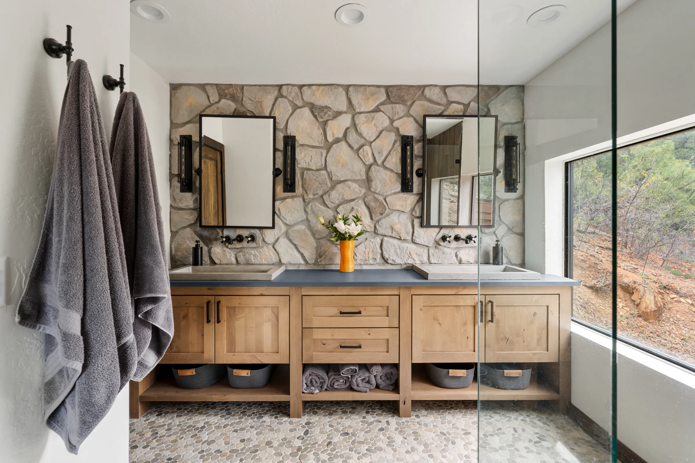 Primary bathroom with stone wall and double vanity, Daybreak at Ponderosa, Refined Designs by Natalie